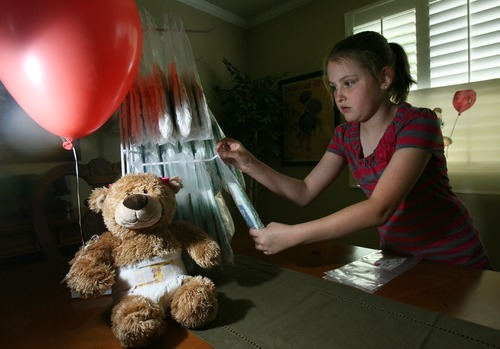 Steve Griffin  |  The Salt Lake Tribune

Nine-year-old Katelynn O'Brien, stocks a display with Ready Bottoms in her Sandy, Utah home Wednesday, June 15, 2011. Katelynn came up with a unique idea for her school's invention fair: a diaper with a pocket for wipes. She and her mother, Aimee O'Brien, have patented the invention and have started a home-based business called Ready Bottoms.